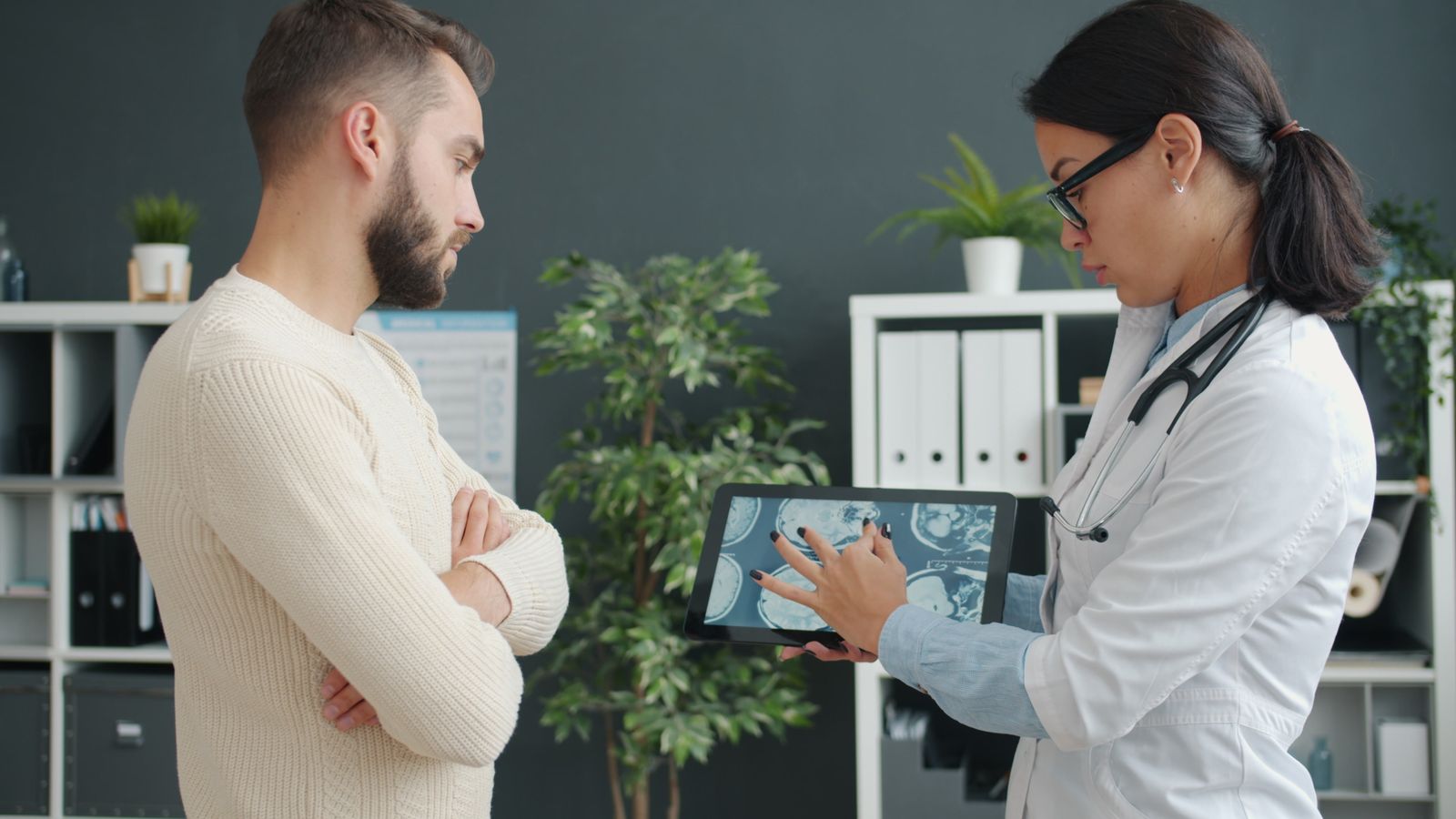 Doctor reviewing results on a tablet with Doctor reviewing results on a tablet with a male patient to decide whether TRT is appropriate