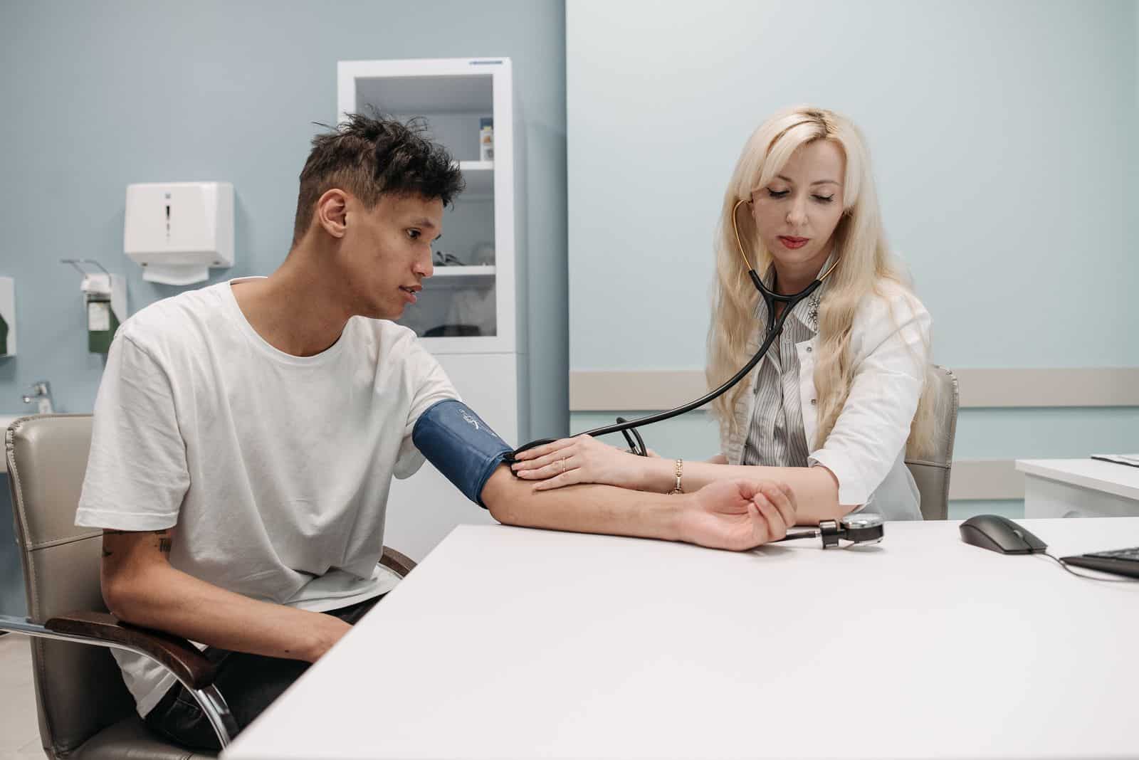 Clinician checking a male patient’s blood pressure Clinician checking a male patient’s blood pressure during a preventive visit