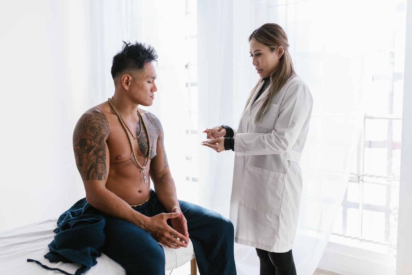 Doctor evaluating a male patient during an Doctor evaluating a male patient during an exam about energy, weight, or hormone concerns