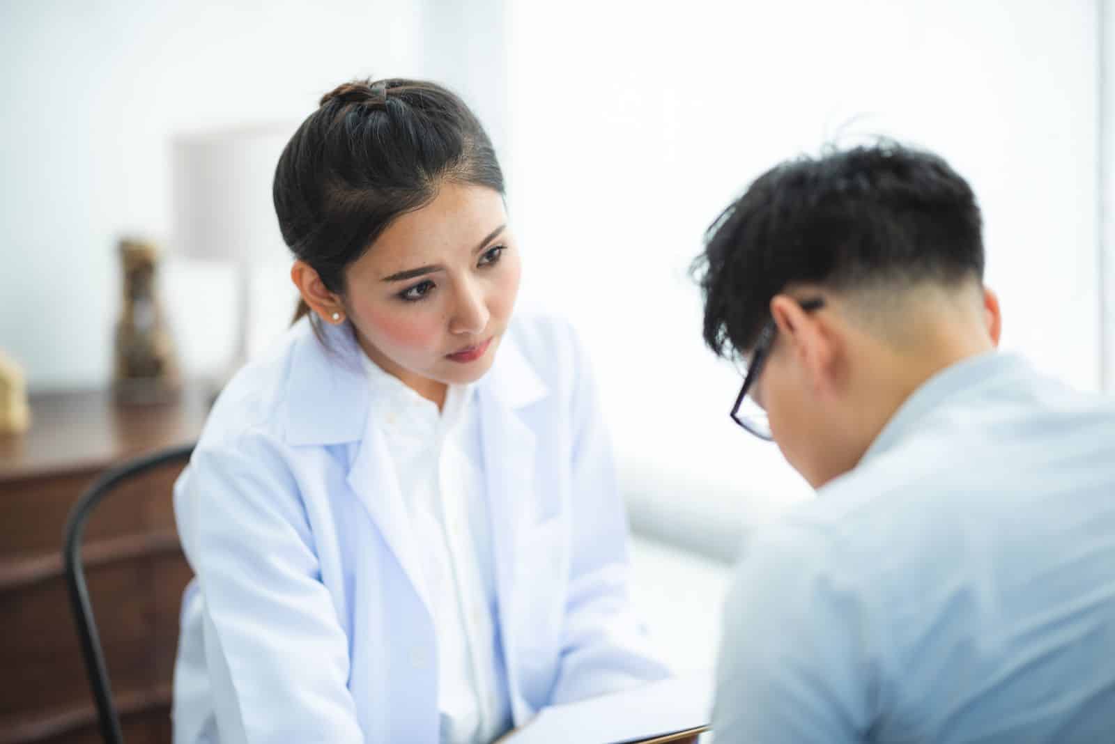 Physician listening to a male patient during Physician listening to a male patient during a follow-up primary care visit