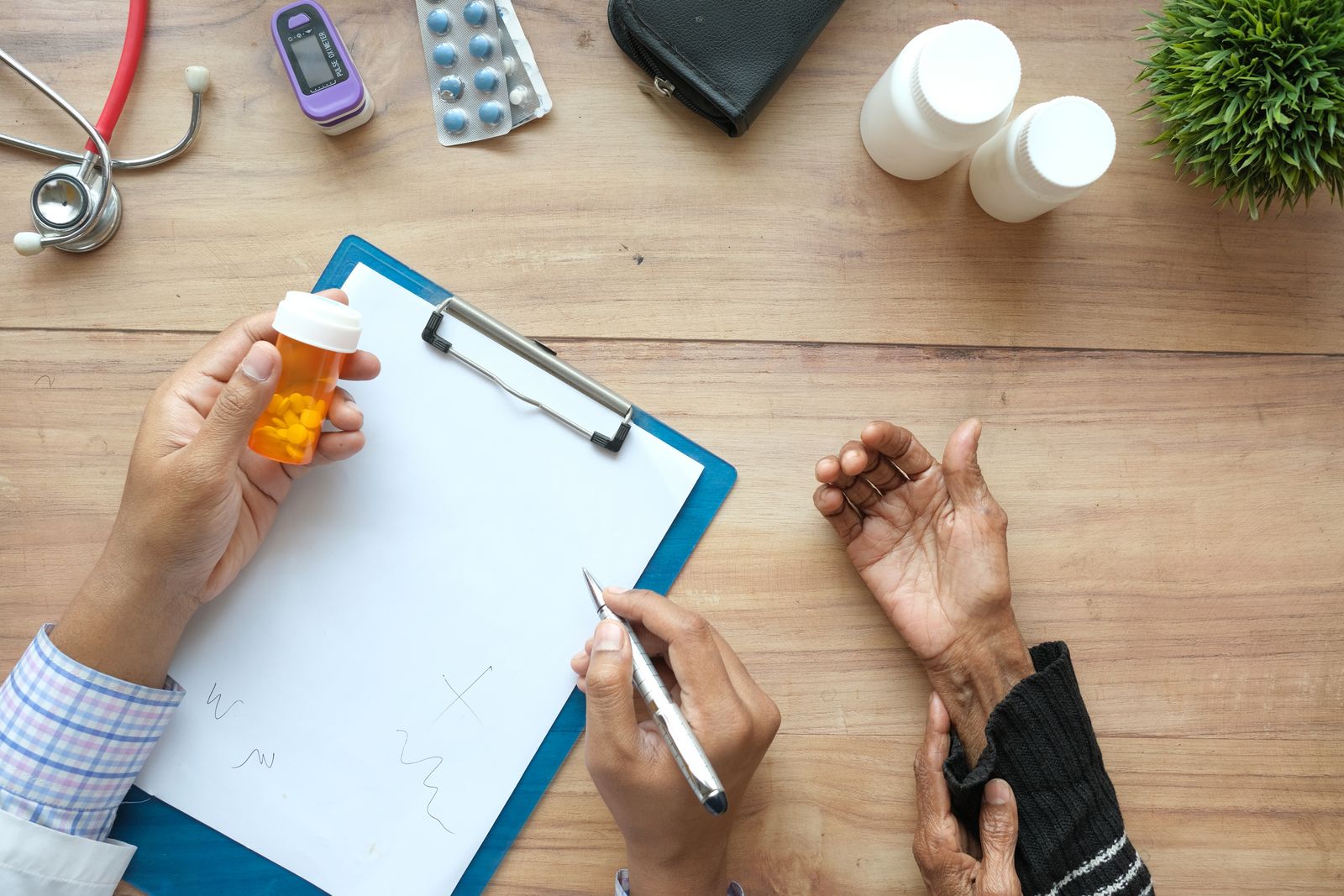 Clinician writing a prescription on a clipboard Clinician writing a prescription on a clipboard beside a medication bottle