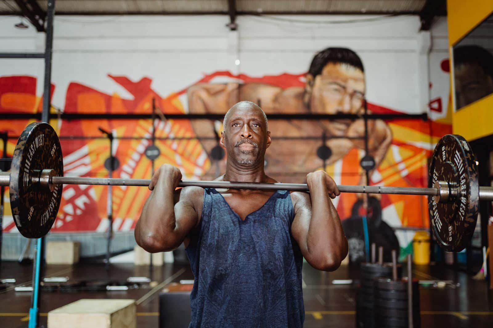 Middle-aged man lifting a barbell during strength Middle-aged man lifting a barbell during strength training